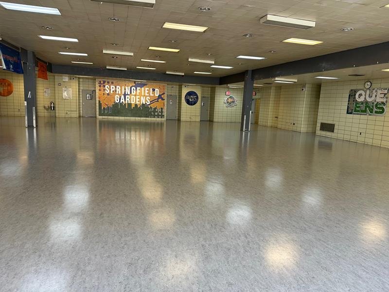 Empty cafeteria with polished floor and campus mural