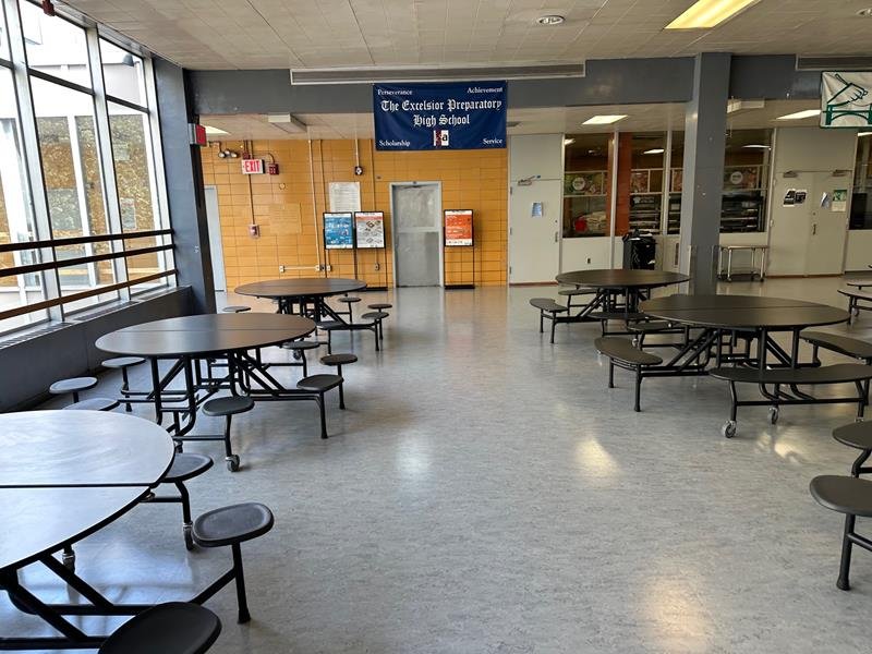 Renovated campus cafeteria with round tables and large windows