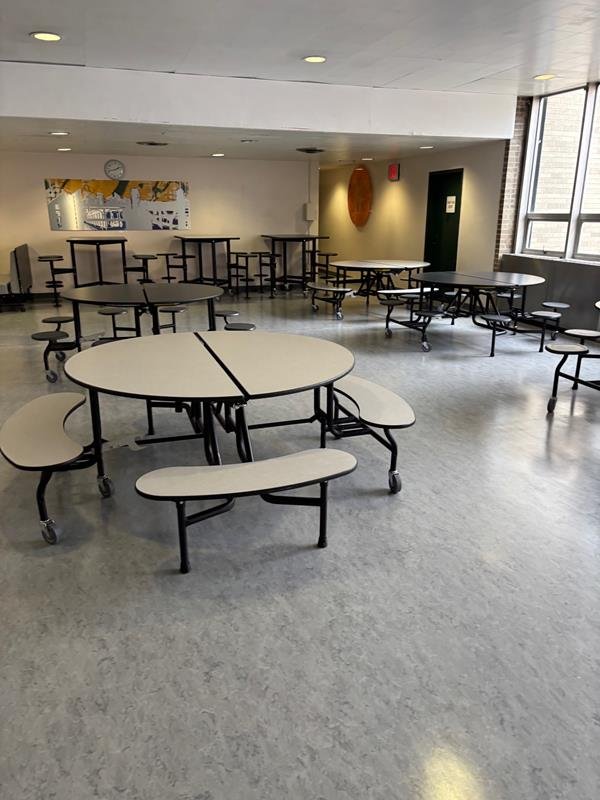 Renovated school cafeteria with round tables and bright finishes