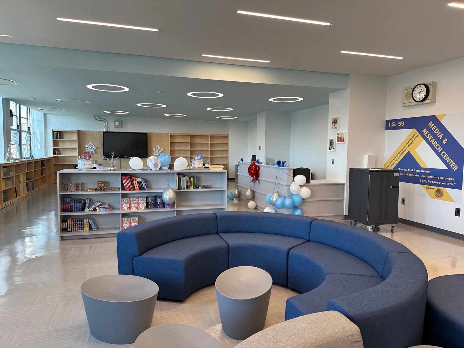 Renovated media and research center at I.S. 59 in Queens with curved blue seating and ring lighting