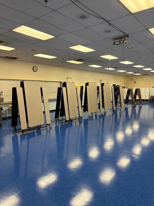 Multipurpose room with new blue flooring and folded tables