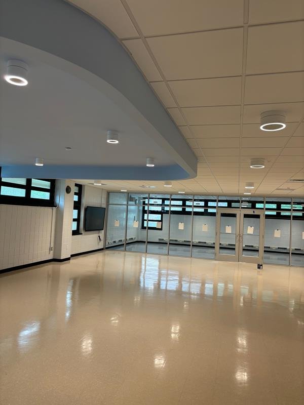 Multipurpose room with curved blue soffit and glazed partition wall