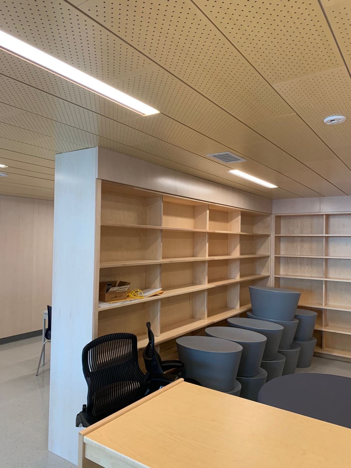 Library at Thomas Edison High School during fit-out with maple shelving, perforated wood ceiling and new seating
